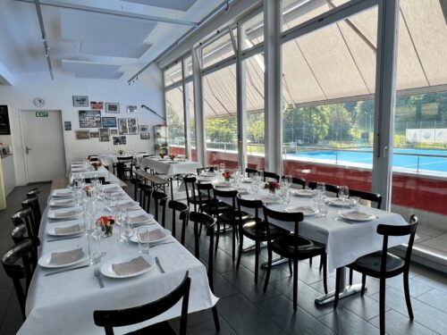 Clubhaus Feier Luzern längs gedeckt mit weissem Tischtuch und Blumengedeck